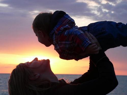 Bild av mor och barn på strand i solnedgång. Personerna på bilden är inte de samma som de i artikeln.