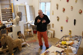 Sverker Eklund stående i sin ateljé, omgiven av sina projekt och alster