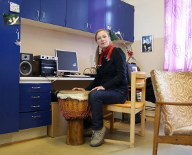 Anna Gustavsson sittandes vid bongotrumma på sitt arbetsrum